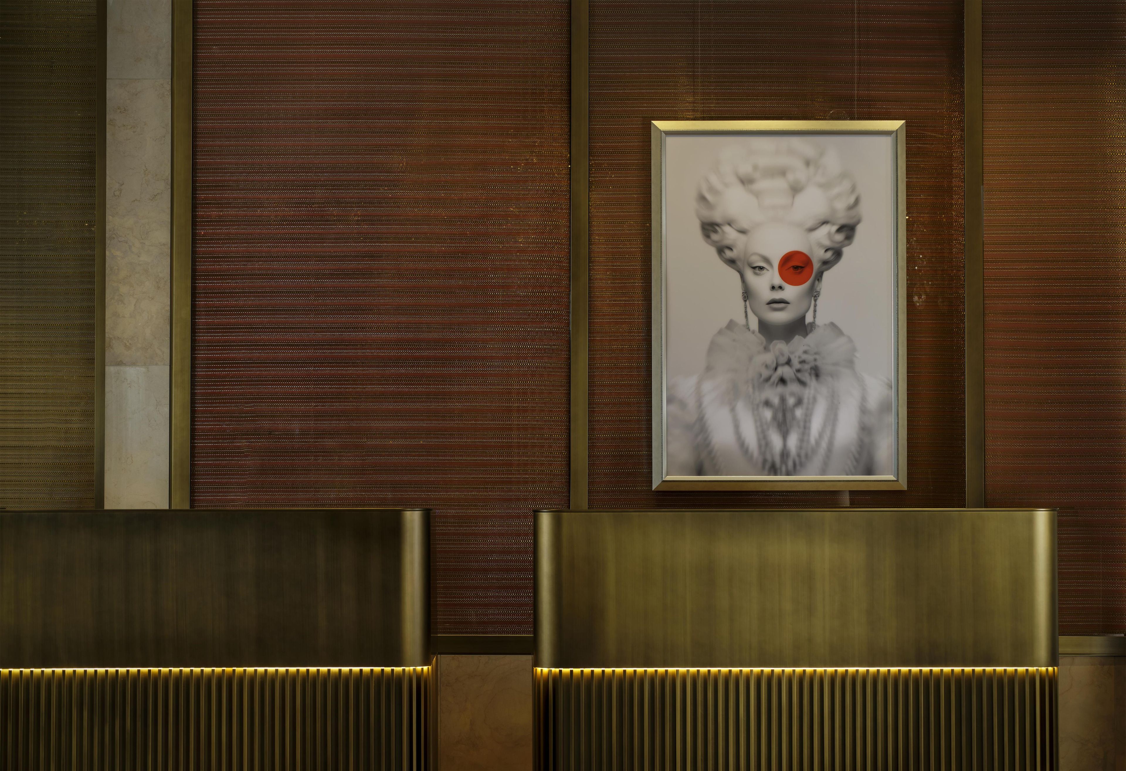 A reception area with a framed portrait on the wall, a reception desk, and a patterned wall.