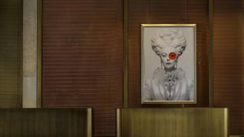 A reception area with a framed portrait on the wall, a reception desk, and a patterned wall.