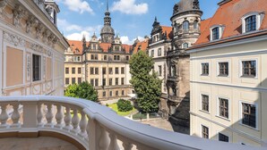 A historic building with ornate architecture, a courtyard, and a clear blue sky.