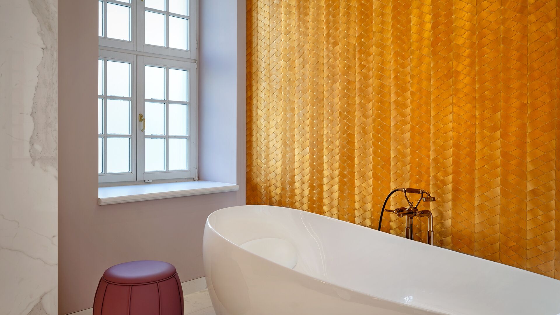 Un baño con una bañera independiente, un ventanal con marcos blancos y una cortina estampada.
