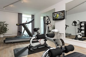 Stay fit on the go with a fully equipped home gym featuring a treadmill, elliptical trainer, and stationary bike.