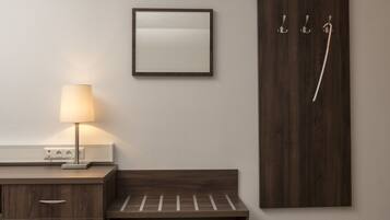 A modern bathroom with a wooden vanity, a wall-mounted mirror, and a towel rack.