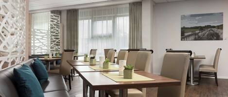 A conference room with a long table, chairs, and a sofa.