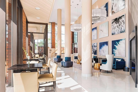A spacious lobby with high ceilings, large windows, and modern seating arrangements.