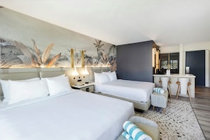 A hotel room with two beds, a small desk, and a large wall mural. - Maui Seaside Hotel (Kahului)