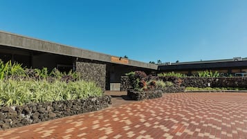 A hotel entrance with a stone wall and a paved walkway.