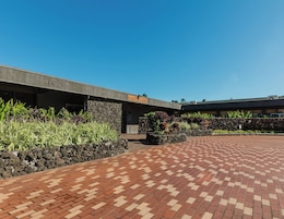 A hotel entrance with a stone wall and a paved walkway.
