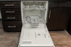 Un lave-vaisselle ouvert, doté de plusieurs niveaux de paniers et d’un panneau de commande.