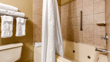 A bathroom with a bathtub, a toilet, and a shower curtain.