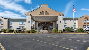 A hotel with a central entrance, a flag, and a sign for 'Quality Inn'.