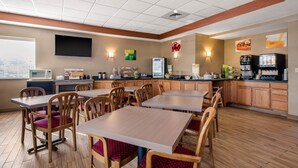 A restaurant with wooden tables and chairs, a coffee machine, and a menu board.