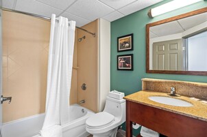 Un baño con bañera, inodoro y lavamanos.