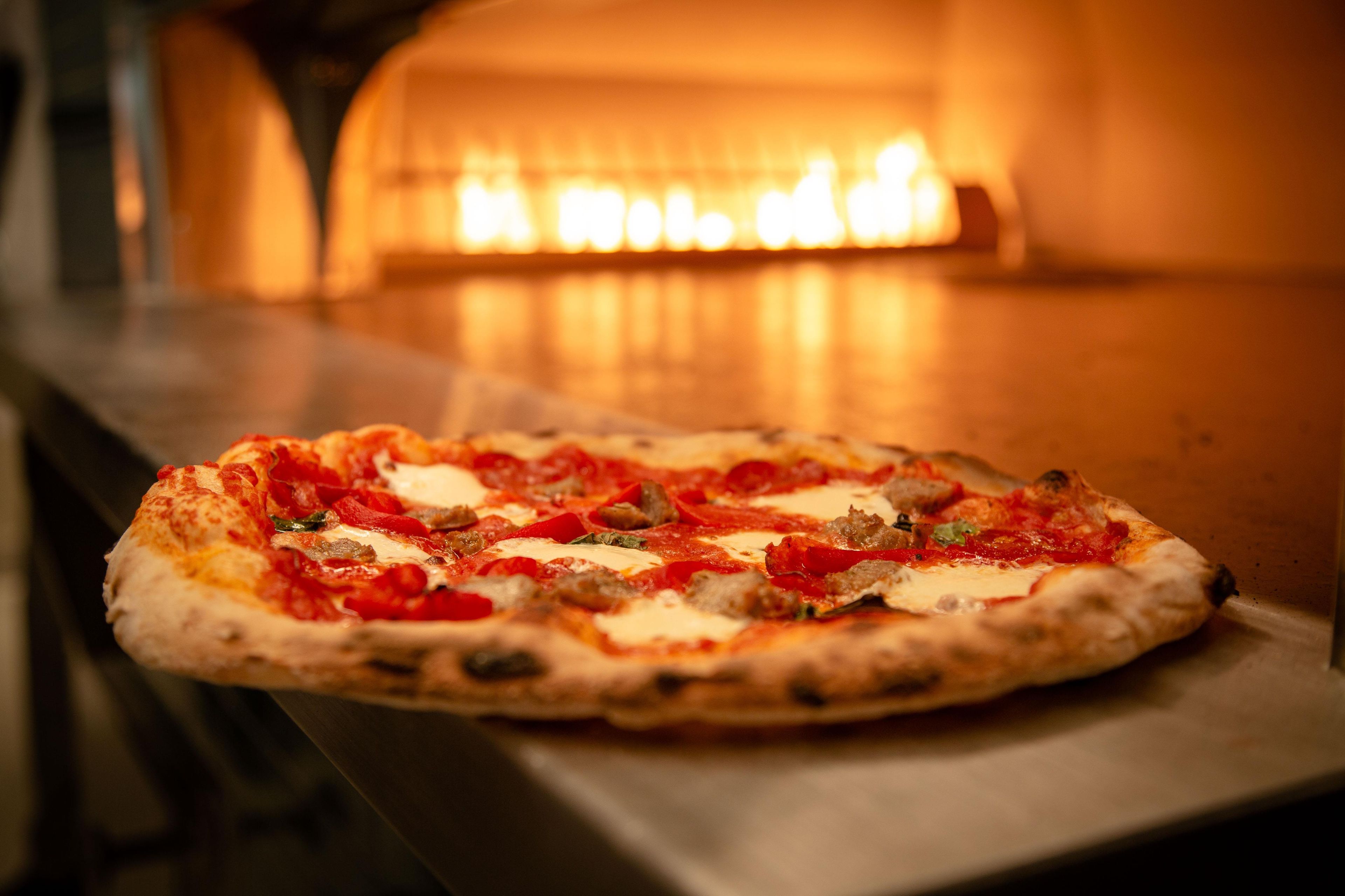 A pizza in a brick oven.