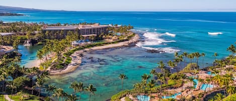 Un resort con piscina, playa y vista al océano.
