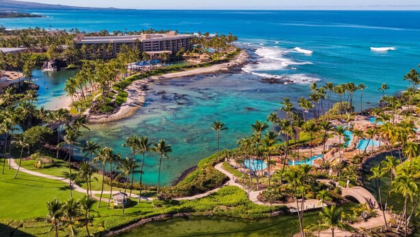 A resort with a pool, beach, and ocean view.