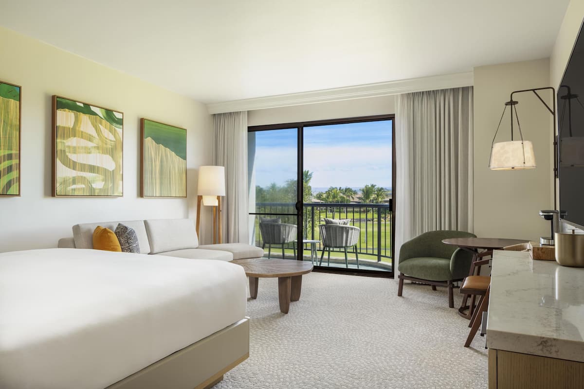 Une chambre d’hôtel comprenant un lit, un canapé, une table à manger, des chaises, un balcon avec vue et des œuvres d’art aux murs.