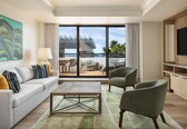 A modern living room with a sofa, chairs, a coffee table, and a TV.