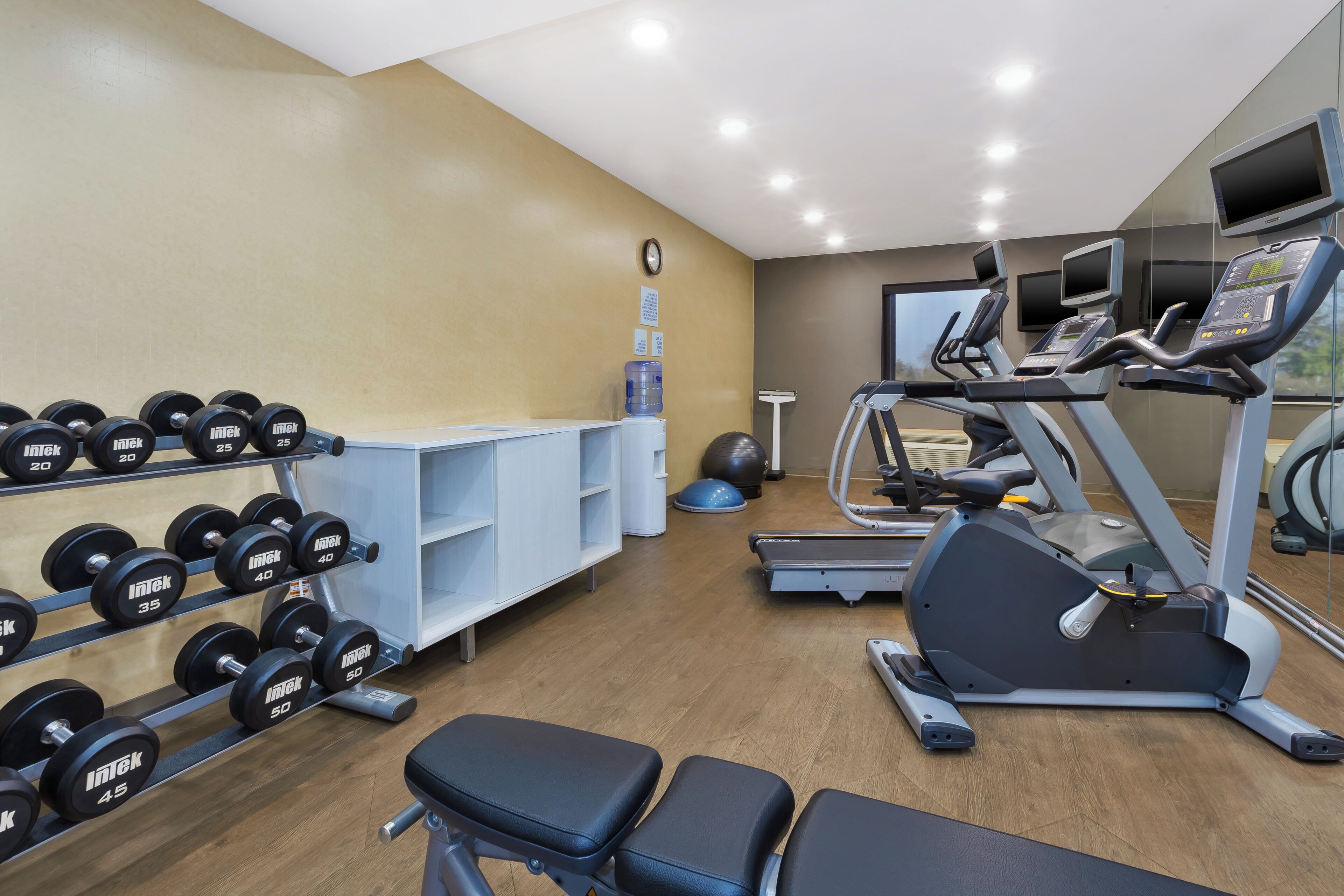 Een sportschool met gewichtrekken, loopbanden en fitnessballen.