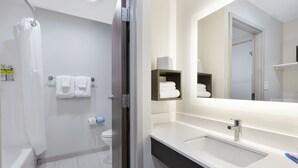 Een moderne badkamer met douche, toilet en wastafel.