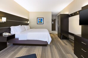 A modern hotel room with a large bed, a desk with a phone, a flat-screen TV, and a dark wooden wardrobe. - Holiday Inn Express Detroit-Warren by IHG (Warren)