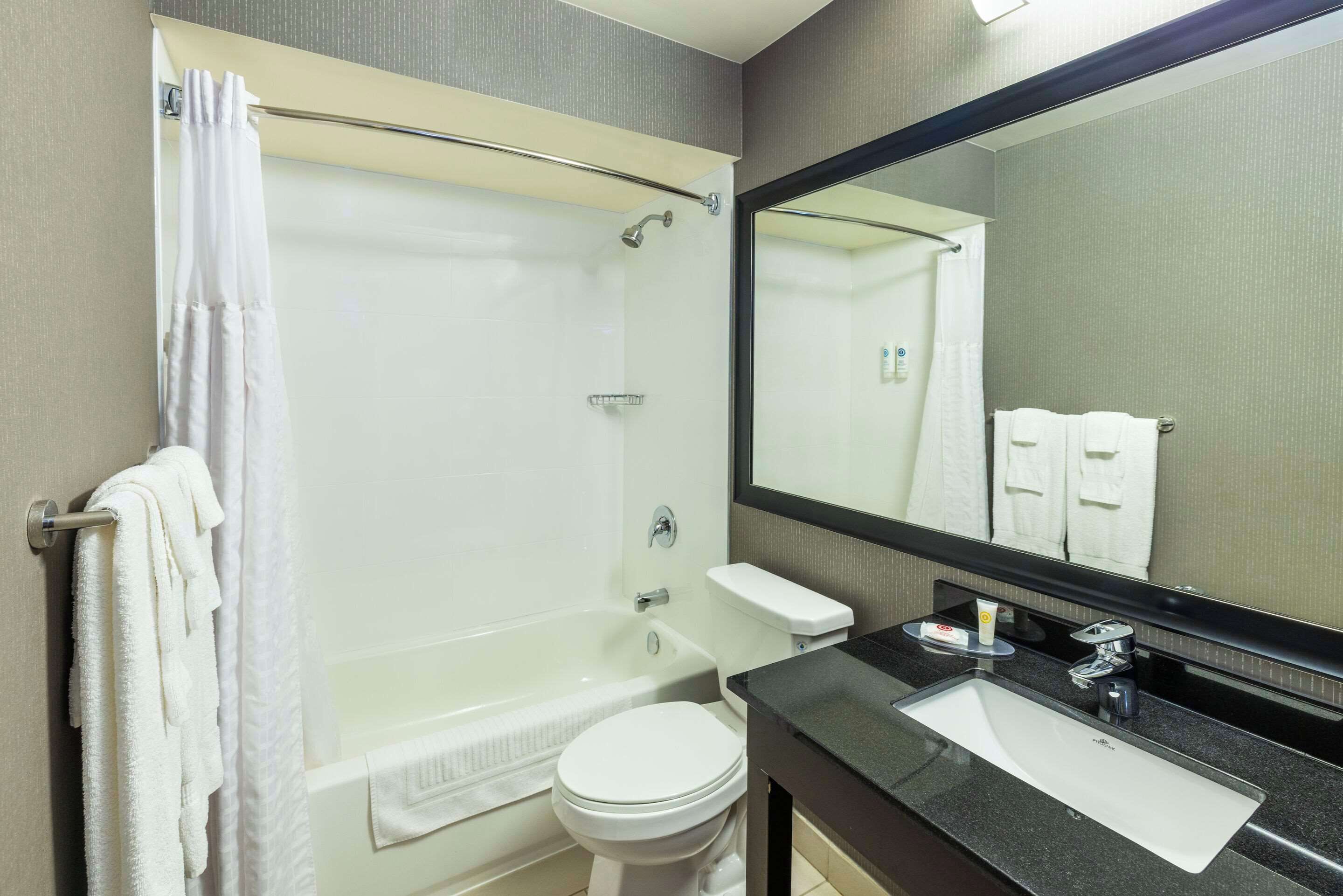 Ein modernes Badezimmer mit Badewanne, Toilette und Waschbecken.