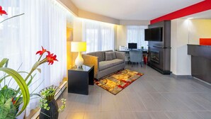 Una sala moderna con sofá, televisor, chimenea y comedor.