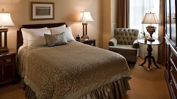 Une chambre d’hôtel bien aménagée, avec un grand lit, une chaise, une petite table et deux lampes.