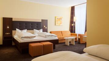 Een hotelkamer met een groot bed, een bank, een kleine tafel en een stoel.
