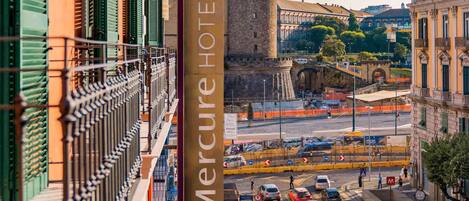 A Mercure Hotel with a view of a historic tower and a busy street below.