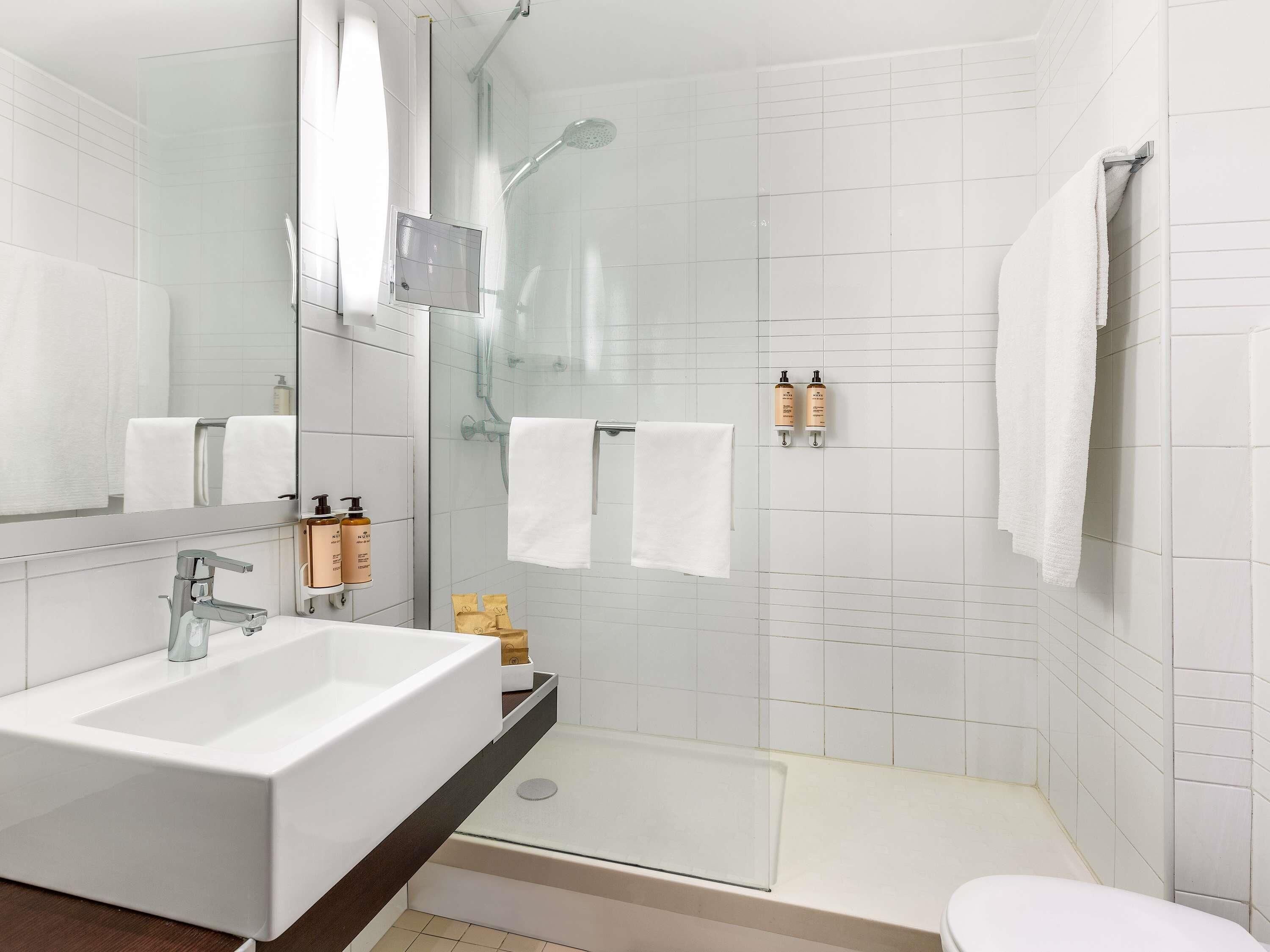 Et moderne badeværelse med en stor vask, en brusekabine med glasvægge og et toilet.