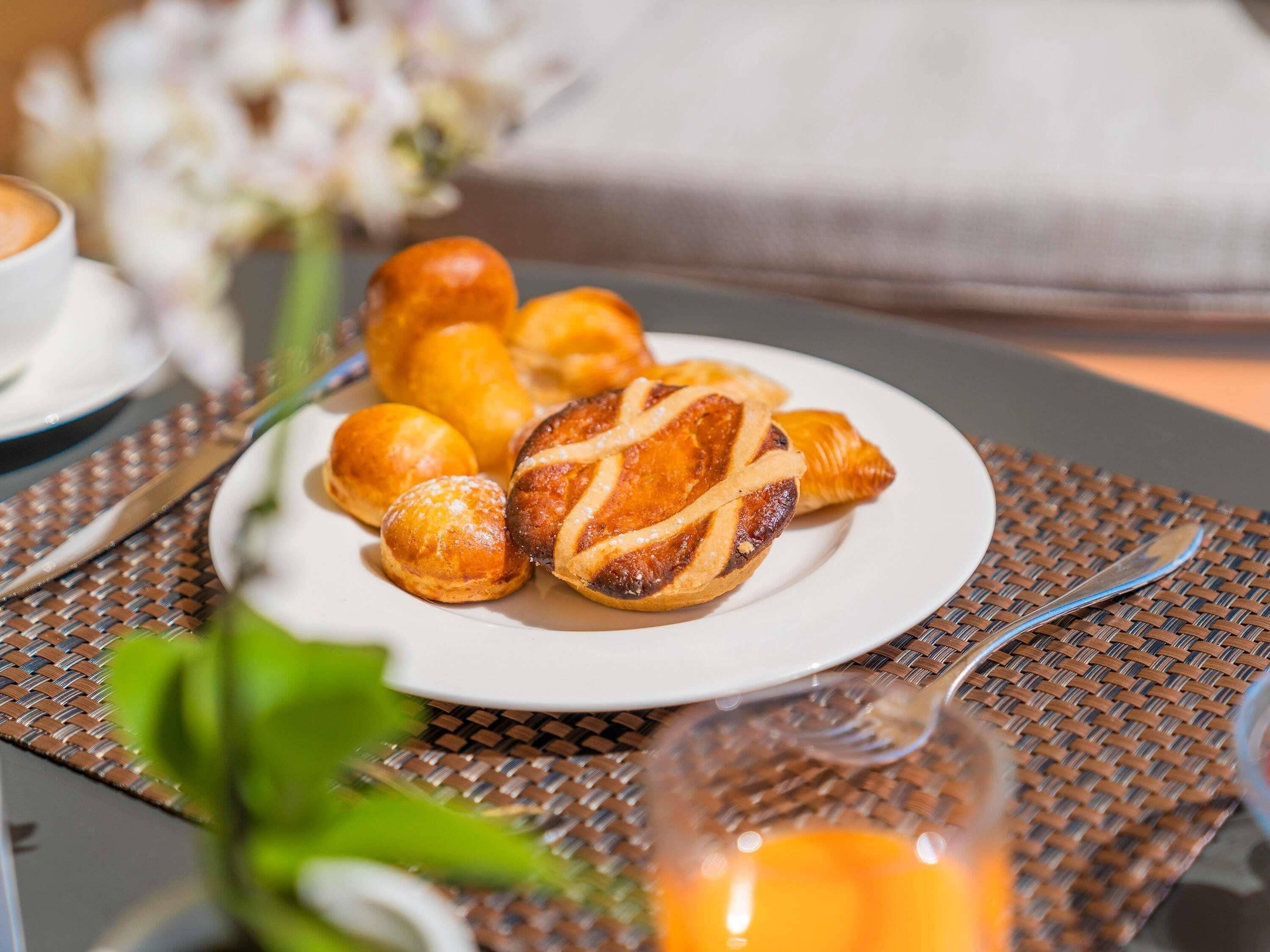 A plate of pastries on a table with a woven placemat.