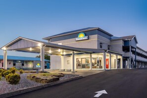 A Days Inn hotel with a covered parking area, a visible entrance, and a clear sky. - Days Inn by Wyndham Greeneville (Greeneville)