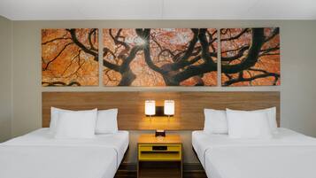 Ein Hotelzimmer mit zwei Betten, einem hölzernen Kopfteil, einem Nachttisch mit einer Uhr und einem Wandbild mit einem Baum.