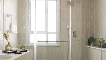 A modern bathroom with a glass-enclosed shower, a toilet, and a vanity with a sink and mirror.