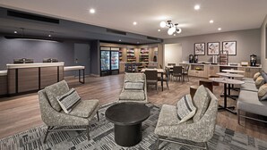 Een moderne loungeruimte met zitplaatsen, een koffiehoek en een snackbar.