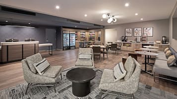 Een moderne loungeruimte met zitplaatsen, een koffiehoek en een snackbar.