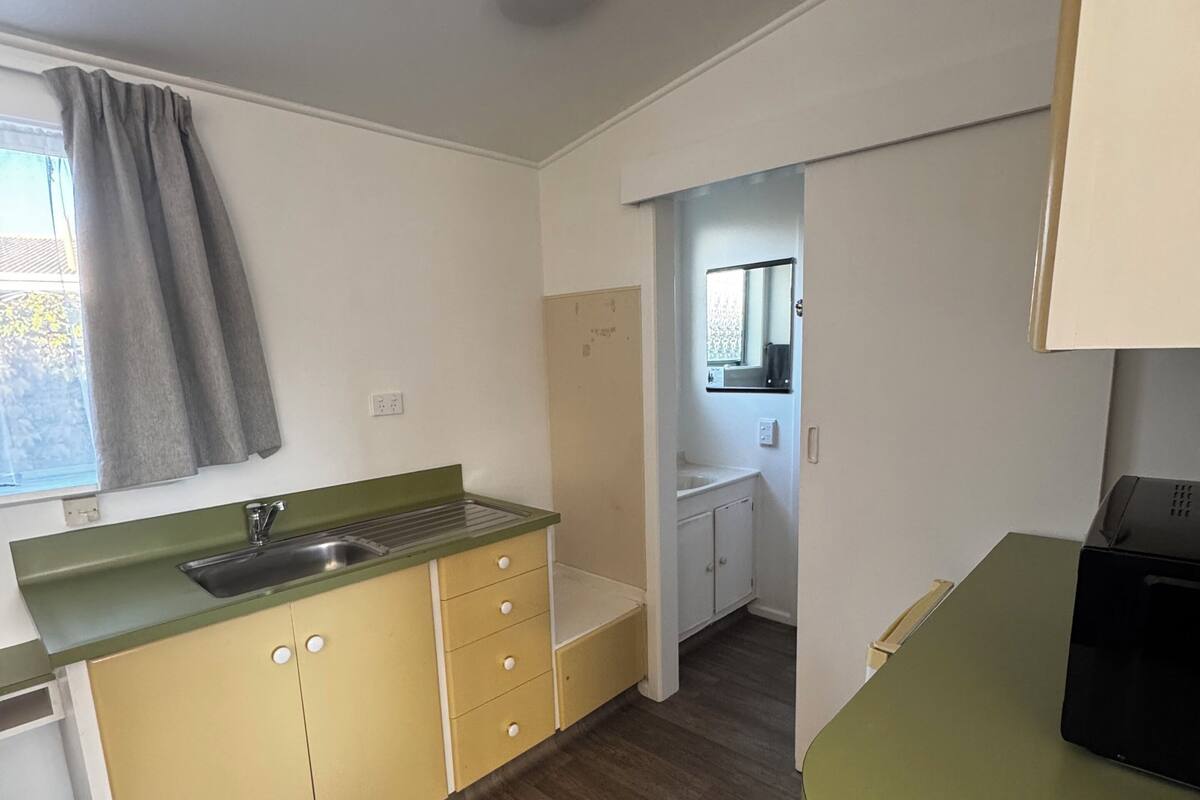 A compact kitchen with a sink, cabinets, and a countertop.