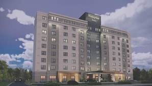 Een meerhoog hotel met een opvallend bord waarop 'Hampton Inn' staat.