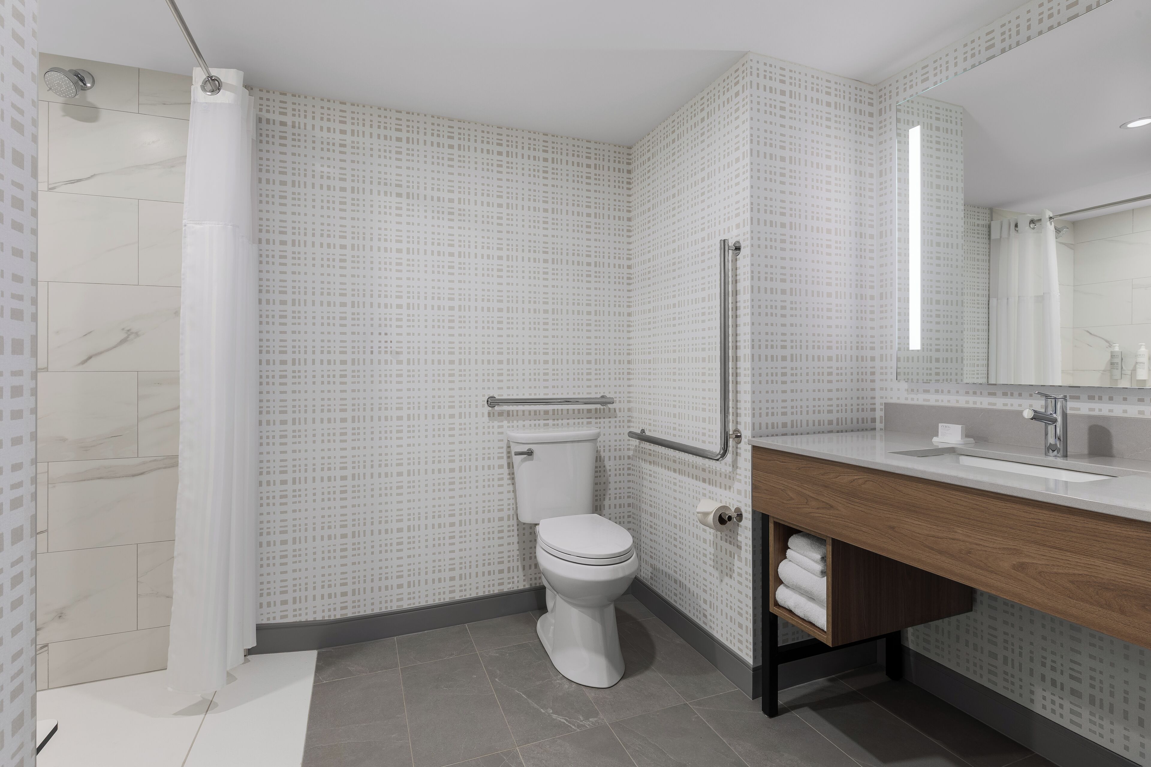 Et moderne badeværelse med toilet, brusebad og håndvask.