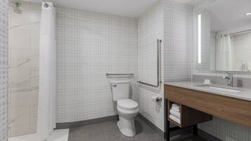 Et moderne badeværelse med toilet, brusebad og håndvask.