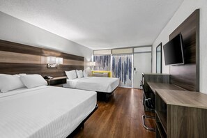 A hotel room with two beds, a desk, a TV, and a window with curtains. - Econo Lodge Carlsbad Caverns Area (Carlsbad)