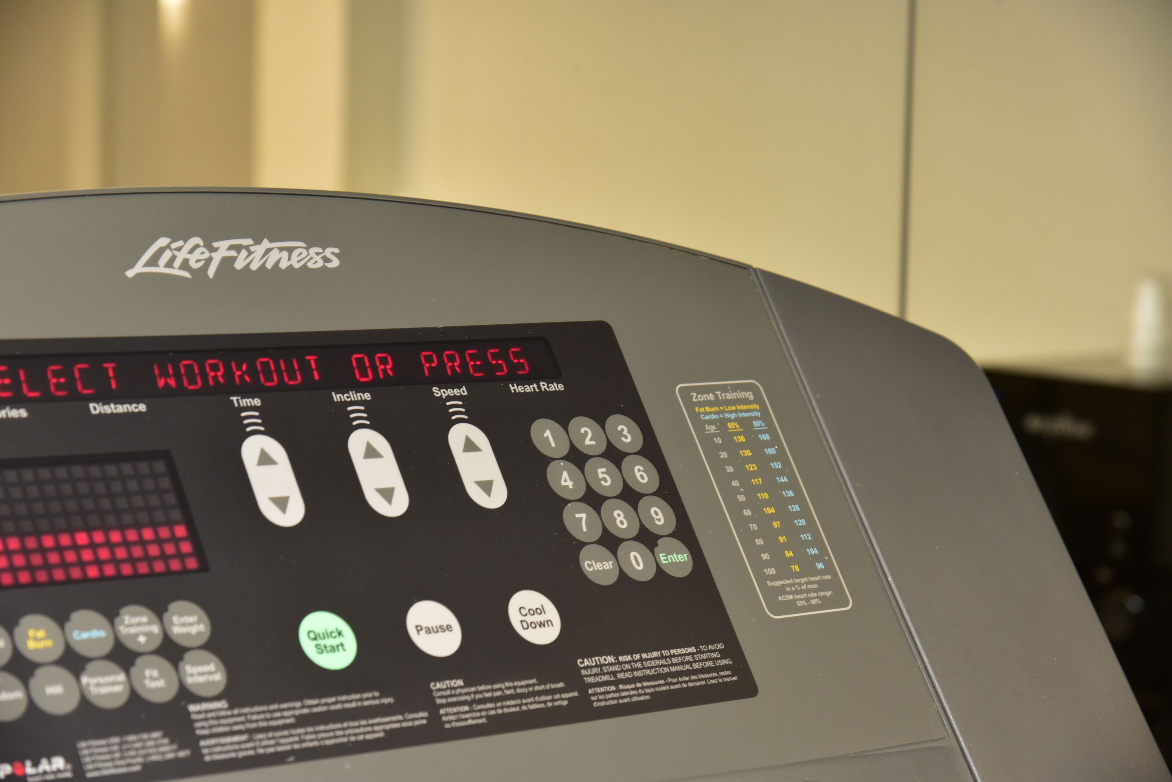 A Life Fitness exercise machine with a digital display and various control buttons.