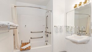 Een badkamer met een bad, een wastafel en een spiegel.