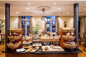 A buffet setup with various food items and a decorative centerpiece. - Hotel Schweizerhof Basel (Basel)