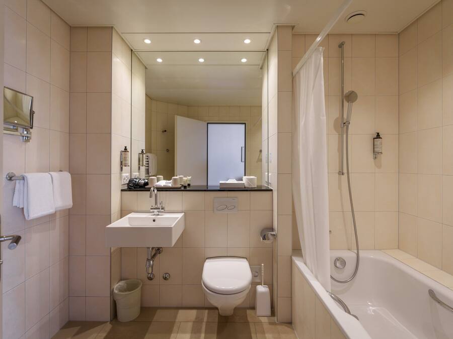 Un baño moderno con lavamanos, inodoro y bañera.
