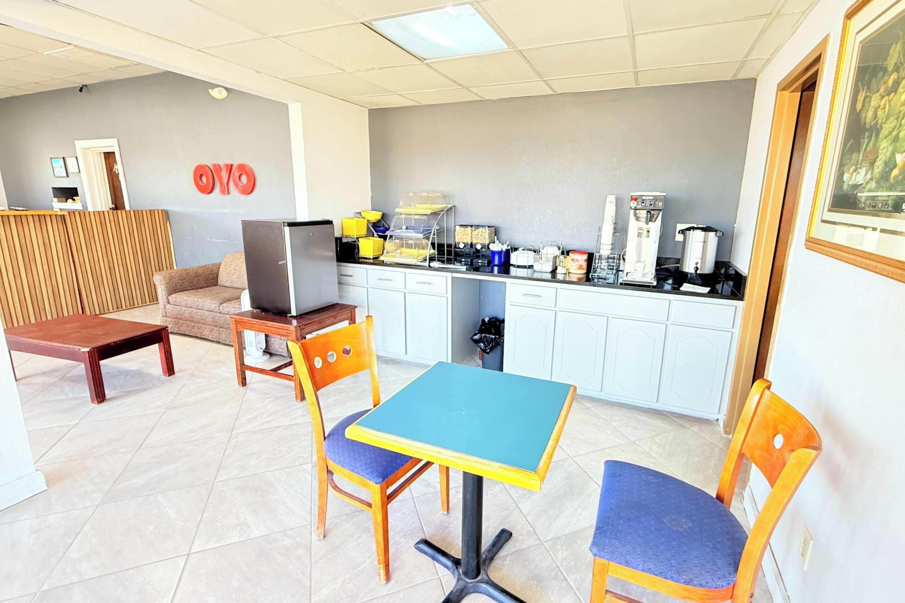 Una habitación pequeña y luminosa con kitchenette, un sofá, una mesa y un televisor.
