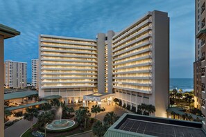 Experience the Hilton's contemporary architecture, surrounded by lush palm trees and a serene fountain.