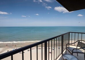 Enjoy the serene ocean views from this balcony overlooking the beach.