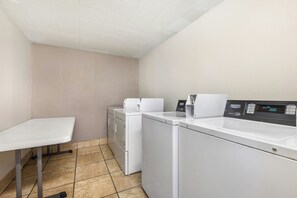 A laundry room with a washing machine, dryer, and a table.