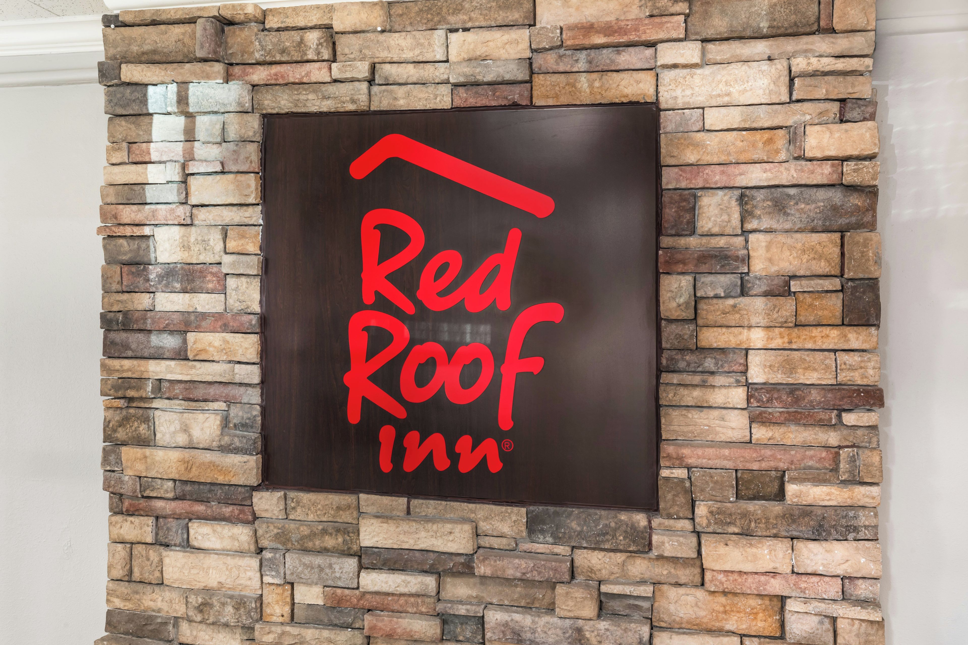 Red Roof Inn -hotellin kyltti on kiinnitetty kiviseinään.